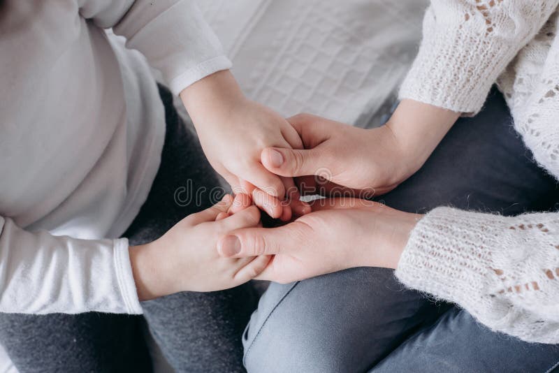 Близкий поднимающий вверх взгляд семьи держа руки, любящ заботящ ребенок матери поддерживая, давая психологическую поддержку стоковые фото